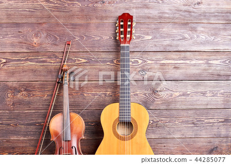 Acoustic guitar and violin on wooden background. Acoustic guitar and violin on wooden background. 44285077