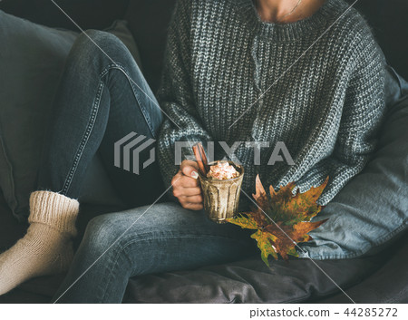 Woman in woolen sweater holding mug with hot chocolate Woman in woolen sweater holding mug with hot chocolate 44285272