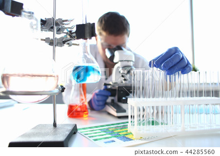 Portrait of a young chemist looking in binocular Portrait of a young chemist looking in binocular 44285560