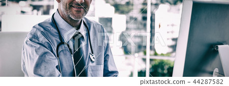 Portrait of smiling doctor working on computer Portrait of smiling doctor working on computer 44287582