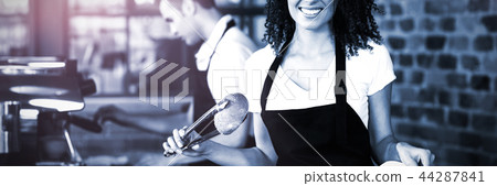 Smiling waitress putting bread roll in paper bag Smiling waitress putting bread roll in paper bag 44287841