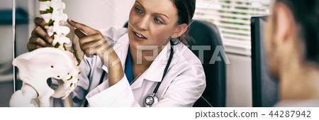 Female doctor pointing on a bone Female doctor pointing on a bone 44287942