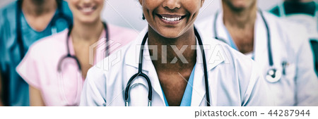 Portrait of smiling female doctor with colleagues Portrait of smiling female doctor with colleagues 44287944