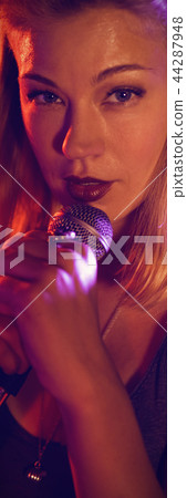 Portrait of singer performing with female drummer in nightclub Portrait of singer performing with female drummer in nightclub 44287948