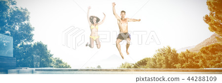 Cheerful couple jumping into swimming pool Cheerful couple jumping into swimming pool 44288109