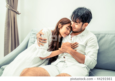 Happy young couple relaxing on sofa in living room 44291981