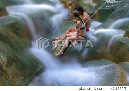 waterfall and leg of woman enjoy in the water 44294225
