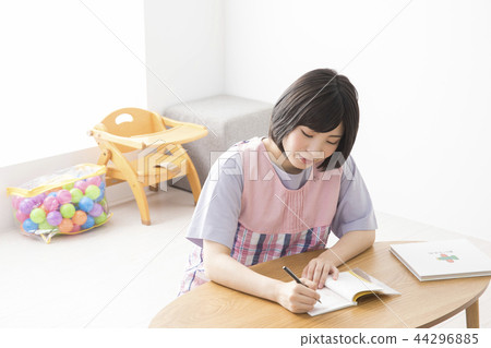 Nursery teacher writing childcare diary 44296885