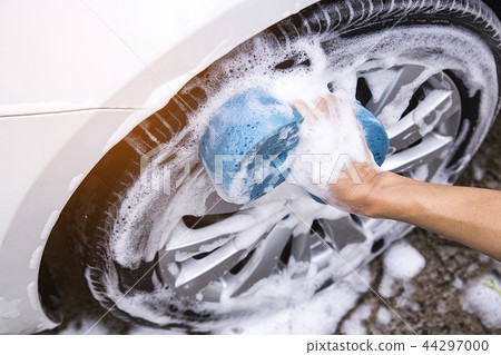 Hand image is holding sponge and car wash. 44297000