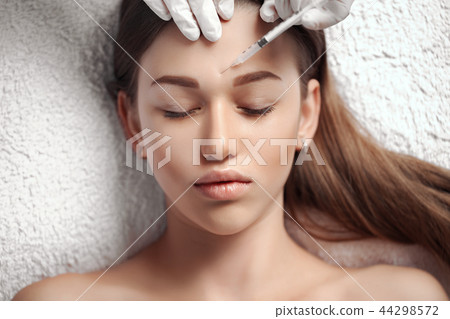 Portrait of young Caucasian woman getting cosmetic injection Portrait of young Caucasian woman getting cosmetic injection 44298572