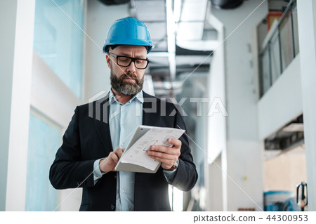Middle-aged engineer in hardhat 44300953