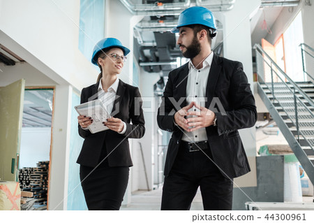 Engineers in hardhats have conversation 44300961