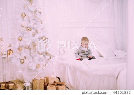 Cheerful little baby boy playing near Christmas tree 44301882