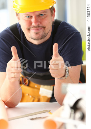 Smiling worker in yellow helmet show confirm sign Smiling worker in yellow helmet show confirm sign 44303724