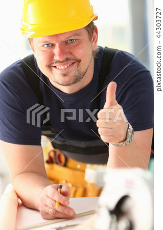 Smiling worker in yellow helmet show confirm sign Smiling worker in yellow helmet show confirm sign 44303727