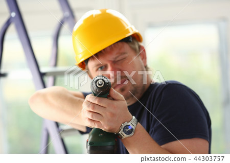 Arms of worker using electric drill closeup 44303757