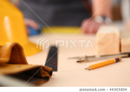 Arms of worker measuring wooden bar closeup 44303804