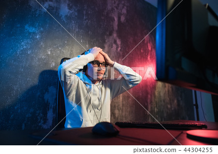 He like play and win video games. In blue light of display emotional man play computer games online. 44304255