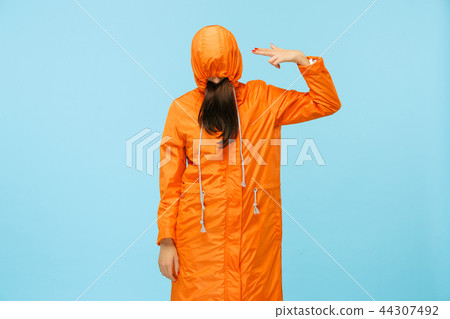 The young girl posing at studio in autumn jacket isolated on blue 44307492