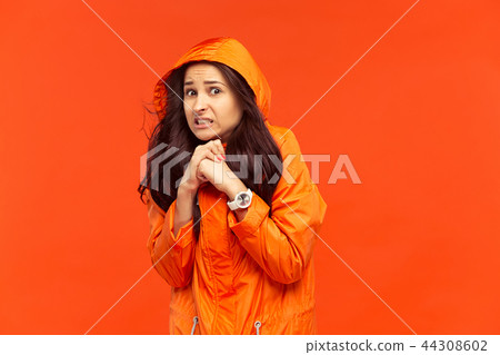 The young girl posing at studio in autumn jacket isolated on red The young girl posing at studio in autumn jacket isolated on red 44308602