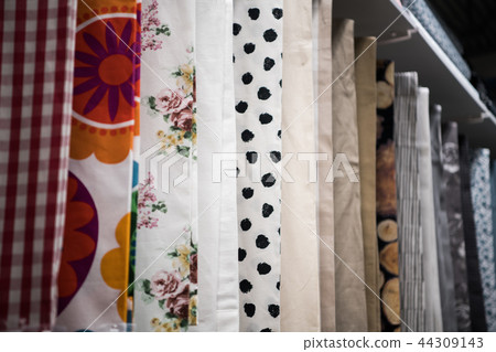 Colorful curtain samples hanging from hangers on rail in a display retail store Multiple color Colorful curtain samples hanging from hangers on rail in a display retail store Multiple color 44309143