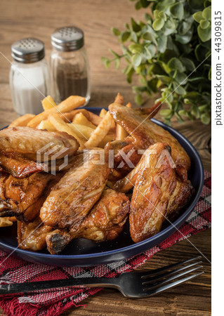 Baked chicken wings with french fries. Baked chicken wings with french fries. 44309815