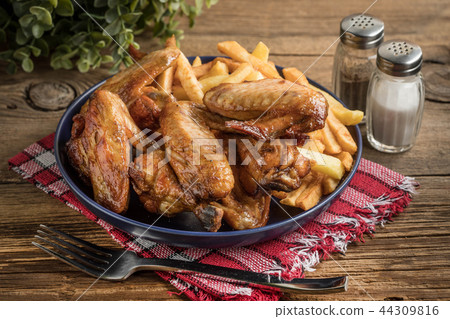 Baked chicken wings with french fries. Baked chicken wings with french fries. 44309816