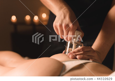 Close-up Hardware cosmetology. Vacuum massage procedure. Male hands install vacuum banks. Close-up 44310929