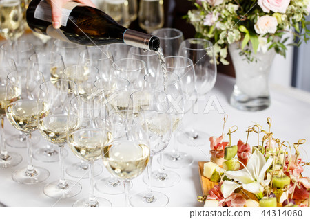 Waiter pouring champagne in the party event. Reception at the wedding party or Banquet for the Waiter pouring champagne in the party event. Reception at the wedding party or Banquet for the 44314060