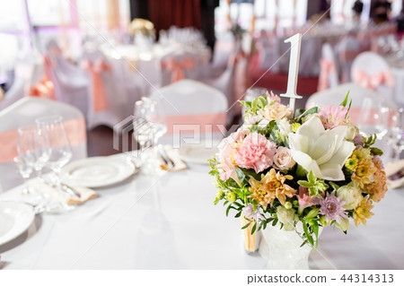 Round table at a luxury wedding reception. Beautiful flowers on the table. Serving dishes, glass 44314313