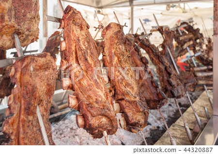 Roasted meat of beef cooking. Asado Argentina 44320887