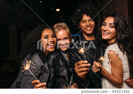 Group of young friends holding sparklers 44321302