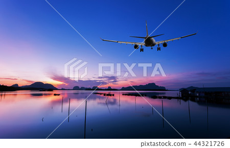 Airplane flying over tropical sea at sunset Airplane flying over tropical sea at sunset 44321726