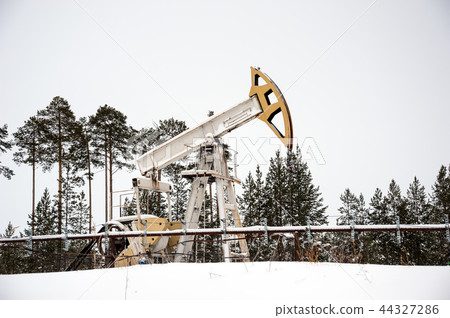 Pump jack situated in forest. 44327286