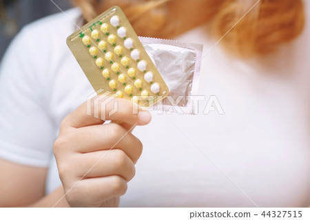 Woman hands give birth control pills  44327515