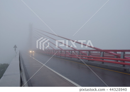 在大霧期間,第一列火車正在上行,並且在橋上進展緩慢。 在大霧期間,第一列火車正在上行,並且在橋上進展緩慢。 44328940