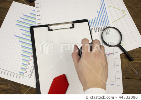 A man's hand puts a seal on a blank sheet, a tie, a magnifying glass 44332080