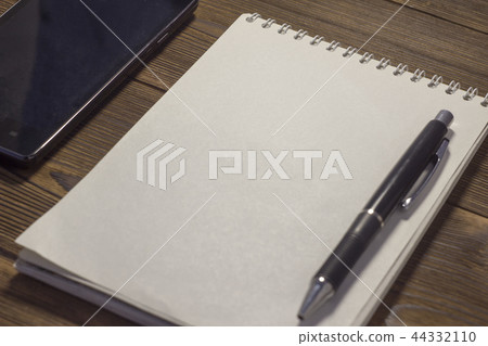 Notepad, phone, pen on a wooden background 44332110