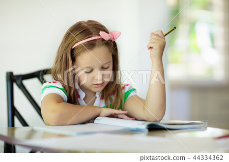 Child doing homework. Kids read and write. 44334362