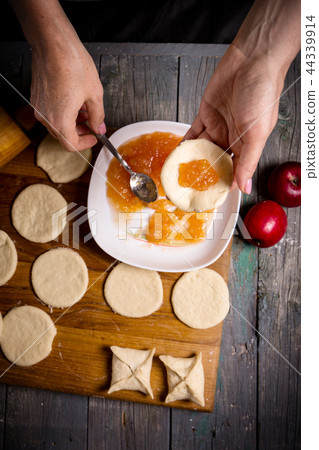 woman making pies with apple jam 44339914
