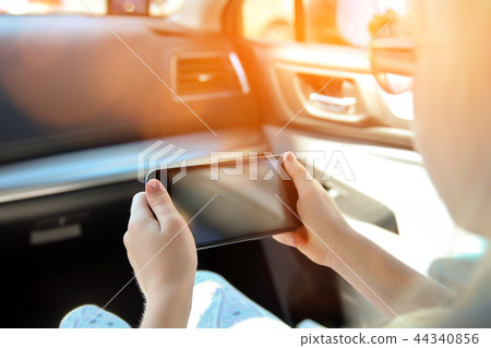 Girl/child sitting in a car with a smartphone 44340856