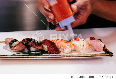 Chef squeezed hot sauce onto multi Japanese Sushi Chef squeezed hot sauce onto multi Japanese Sushi 44340944