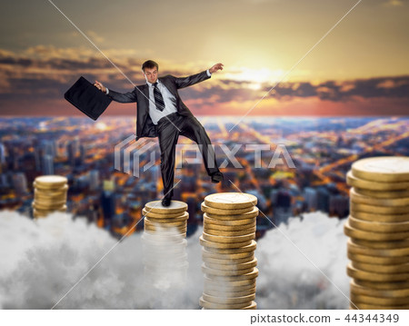 Businessman on stacks of coins, financial balance 44344349