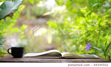 Black coffee cup and notebook on wooden table Black coffee cup and notebook on wooden table 44344502