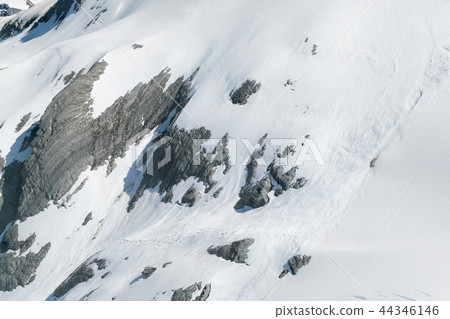 Snow covered rock mountain slope 44346146