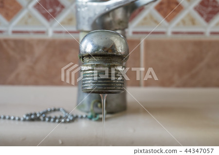 Water tap close-up limescale soiled calcified faucet  flowing 44347057