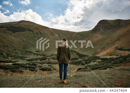 Peaceful woman standing alone and looking at the landscape 44347404