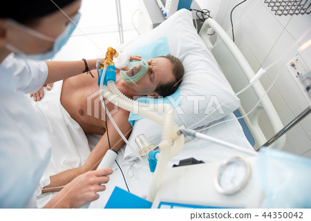 Male patient receiving mechanical ventilation in intensive care ward 44350042