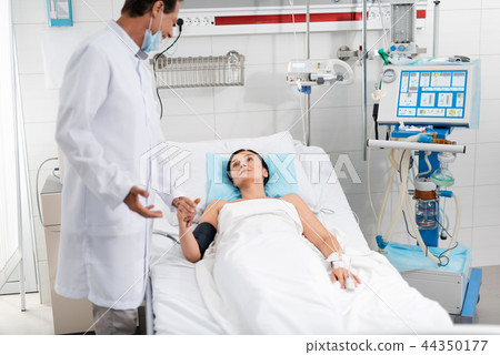 Doctor holding hand of young female patient Doctor holding hand of young female patient 44350177