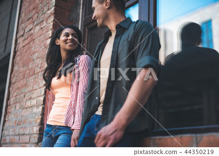 Two young people smiling to each other and holding hands 44350219